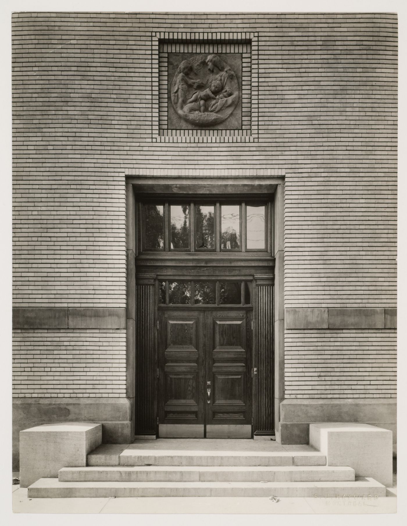 Vue d'une entrée et d'un détail décoratif sur la façade principale, École Saint-Arsène, Montréal, Canada