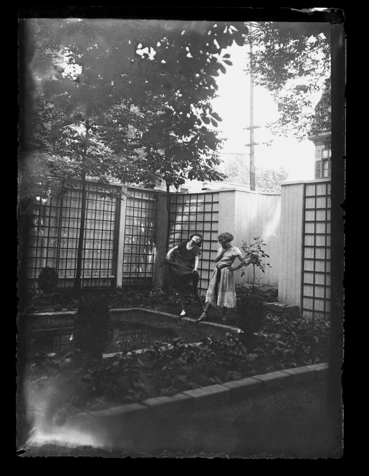 Portrait de Clorinthe et Cécile Perron posant dans le jardin du studio d'Ernest Cormier, Montréal