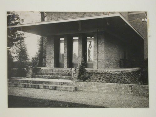 View of a brick house showing three doors, steps and roof