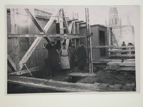 View of the construction site of the first wooden Lenin Mausoleum showing workers with the Nikol'skaya Tower (Nicholas Tower) in the background, Red Square, Moscow