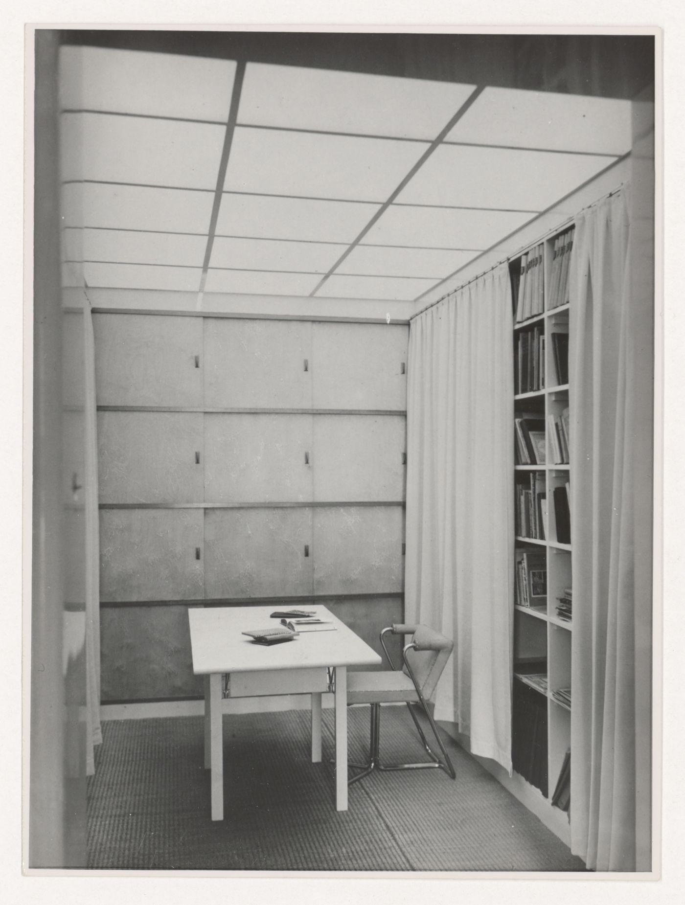Interior view of the library of Hannema House I showing an elbow chair designed by J.J.P. Oud, a dropleaf table and built-in curtained bookshelves, Rotterdam, Netherlands