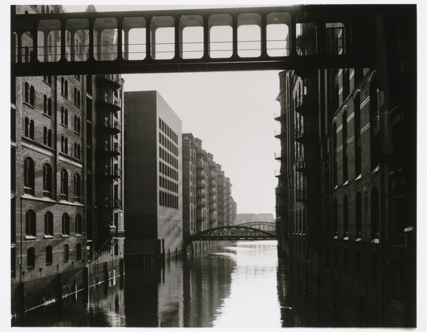 View of Speicherblock T [Storage Block T] of Sicherstadt [Storage City] warehouses showing a skywalk and bridges over Wandrahmsfleet canal, Alter Wandrahm 12, Altstadt, Hamburg, Germany