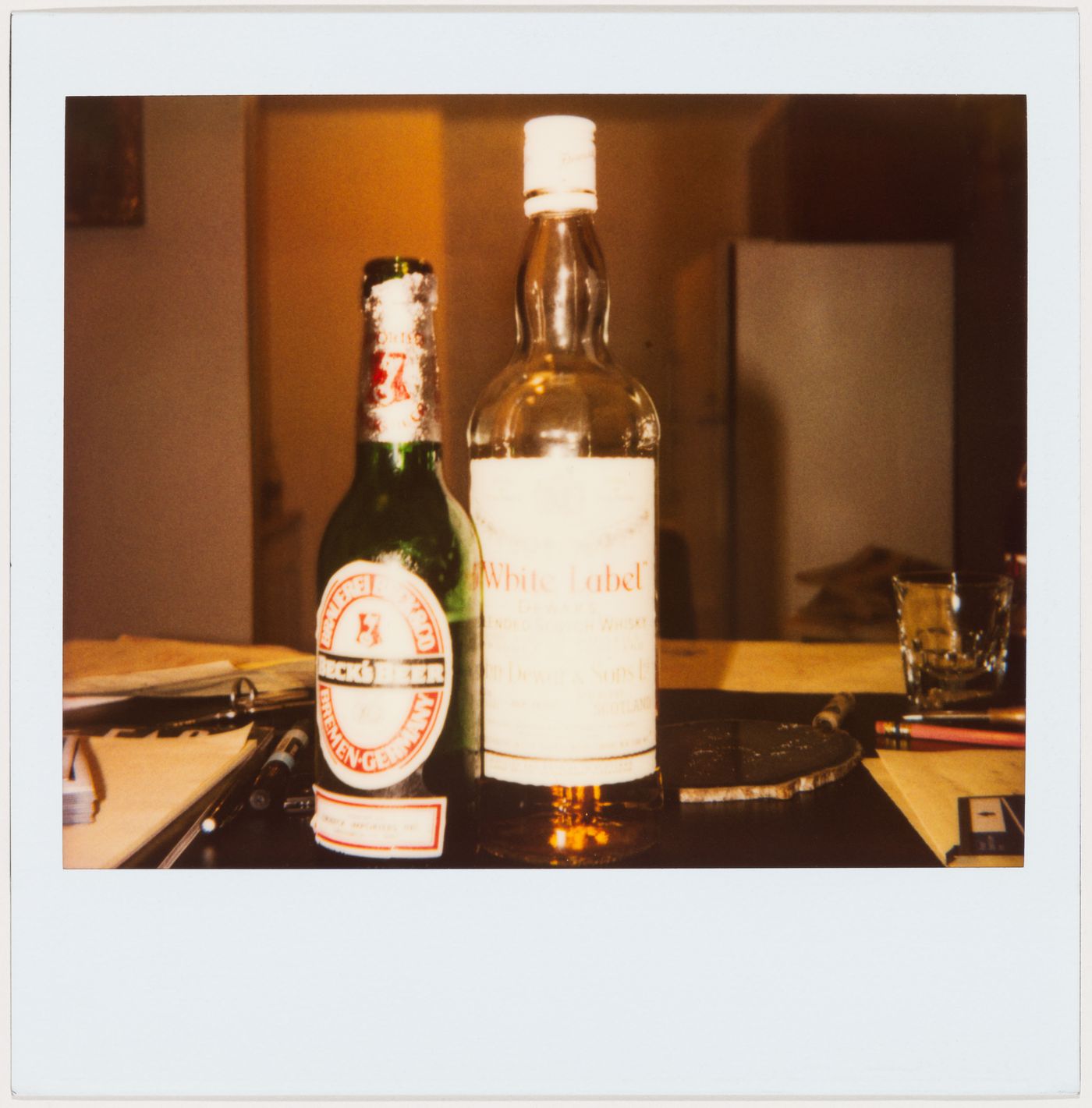 Beck’s Beer and White Label Scotch bottles on a table