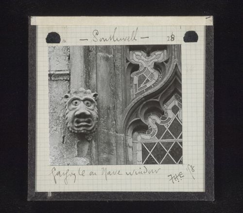 View of grotesque sculpture and partial view of stained glass window of nave at Chapter House, Southwell Minster, Southwell, Nottinghamshire, England