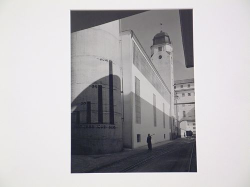 Exterior view of large building with chart on façade, train tracks in foreground, Germany