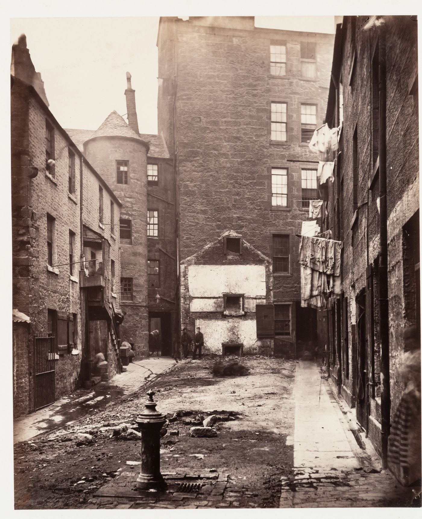 View of Closes Nos. 97 and 103 showing a common water tap or pump in the foreground, Saltmarket [street], Glasgow, Scotland