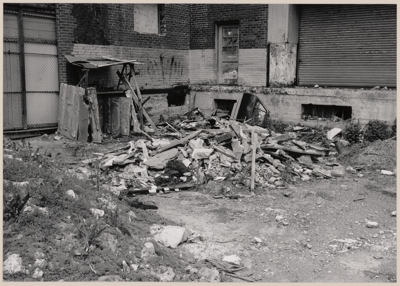 Field Work in Montreal: View of a wooden shack-like structure, a brick wall, an overhead door, refuse and a vacant lot, Montréal, Québec