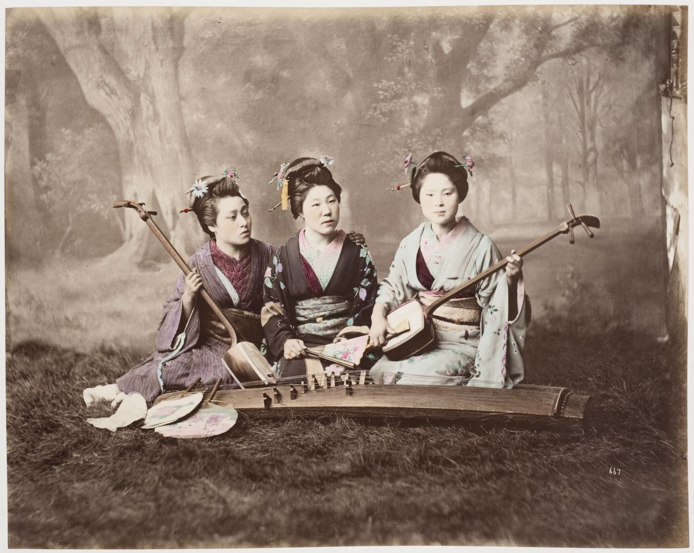 Group portrait of three women with two shamisen, a koto and fans, Japan