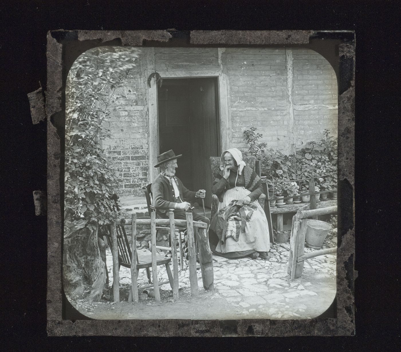 View of unidentified man and woman seated outside