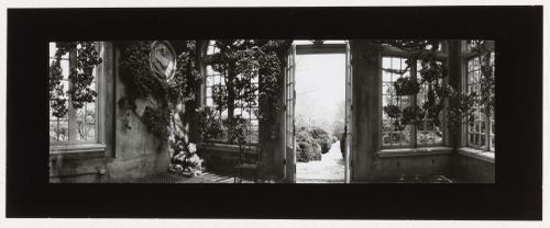 Interior view of the Orangery showing a brick walkway and shrubs through the open door, Dumbarton Oaks, 1703 32nd Street North West, Washington, D.C.