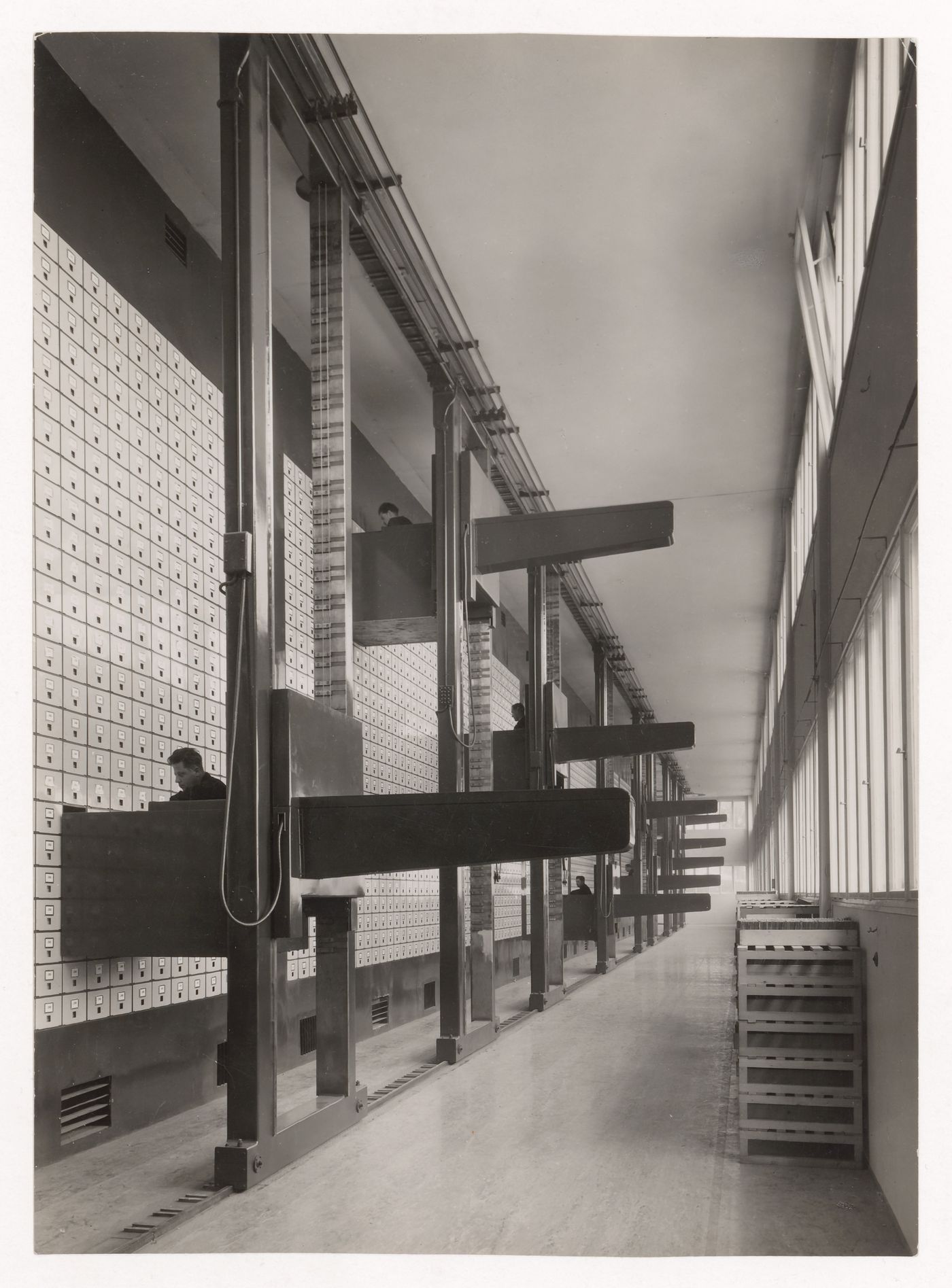 Interior view of the Central Social Insurance Institution showing men working in mobile work stations used to access the card catalog drawers, Prague, Czechoslovakia (now Czech Republic)