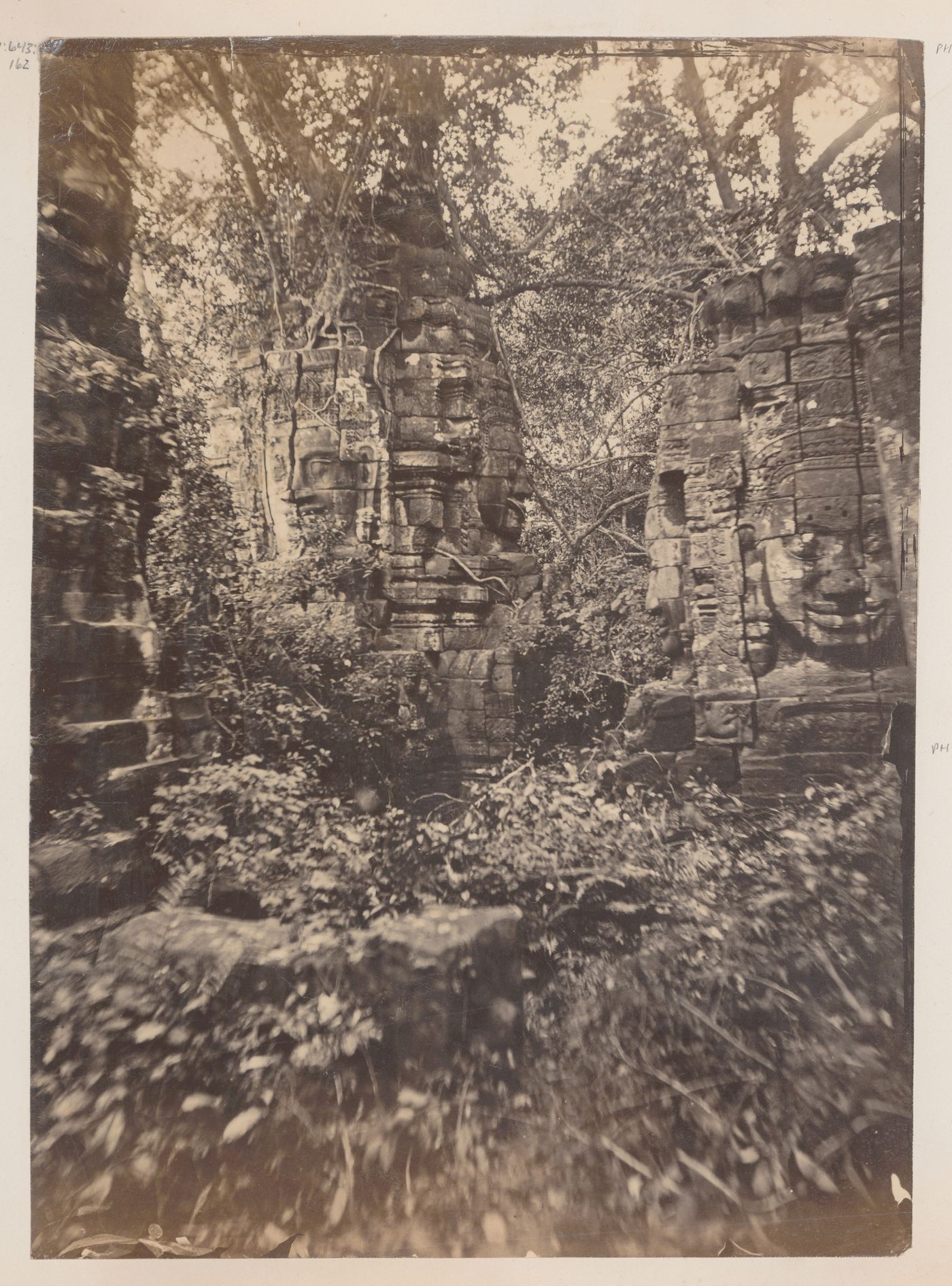 View of stone face towers on the Bayon Temple, Angkor, Siam (now in Cambodia)