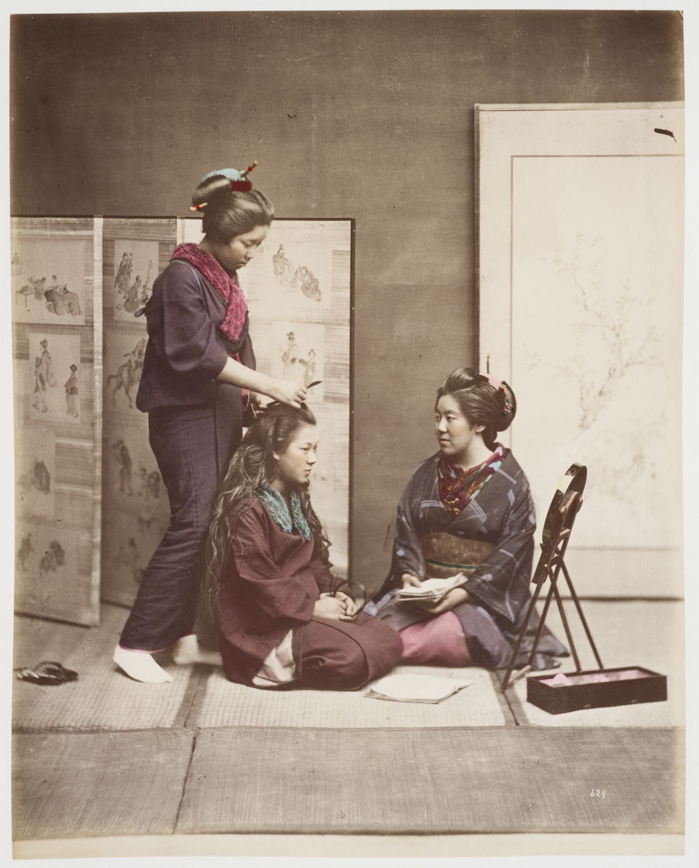 Group portrait of three women grooming, Japan