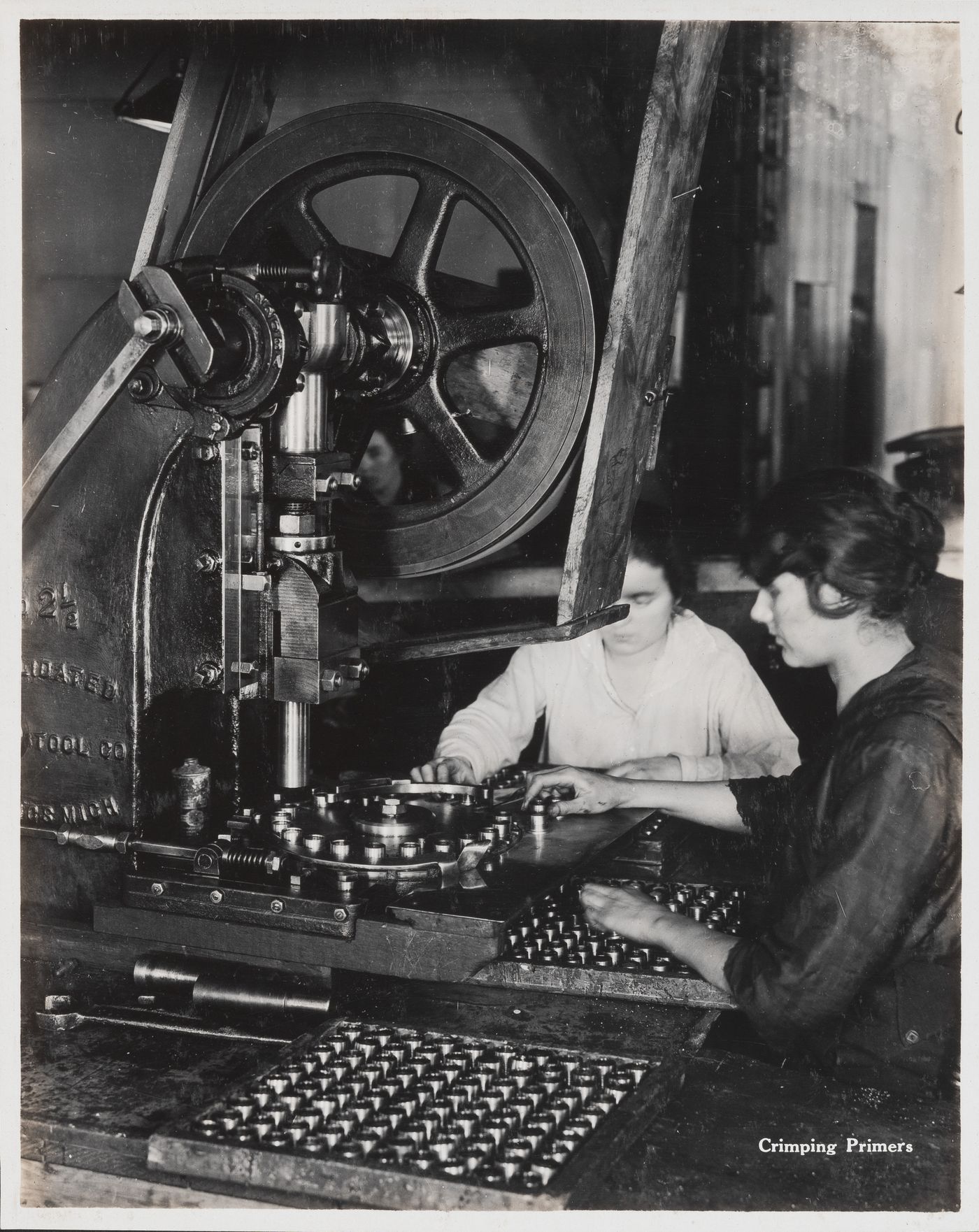 Interior view of workers crimping primers at the Energite Explosives Plant No. 3, the Shell Loading Plant, Renfrew, Ontario, Canada