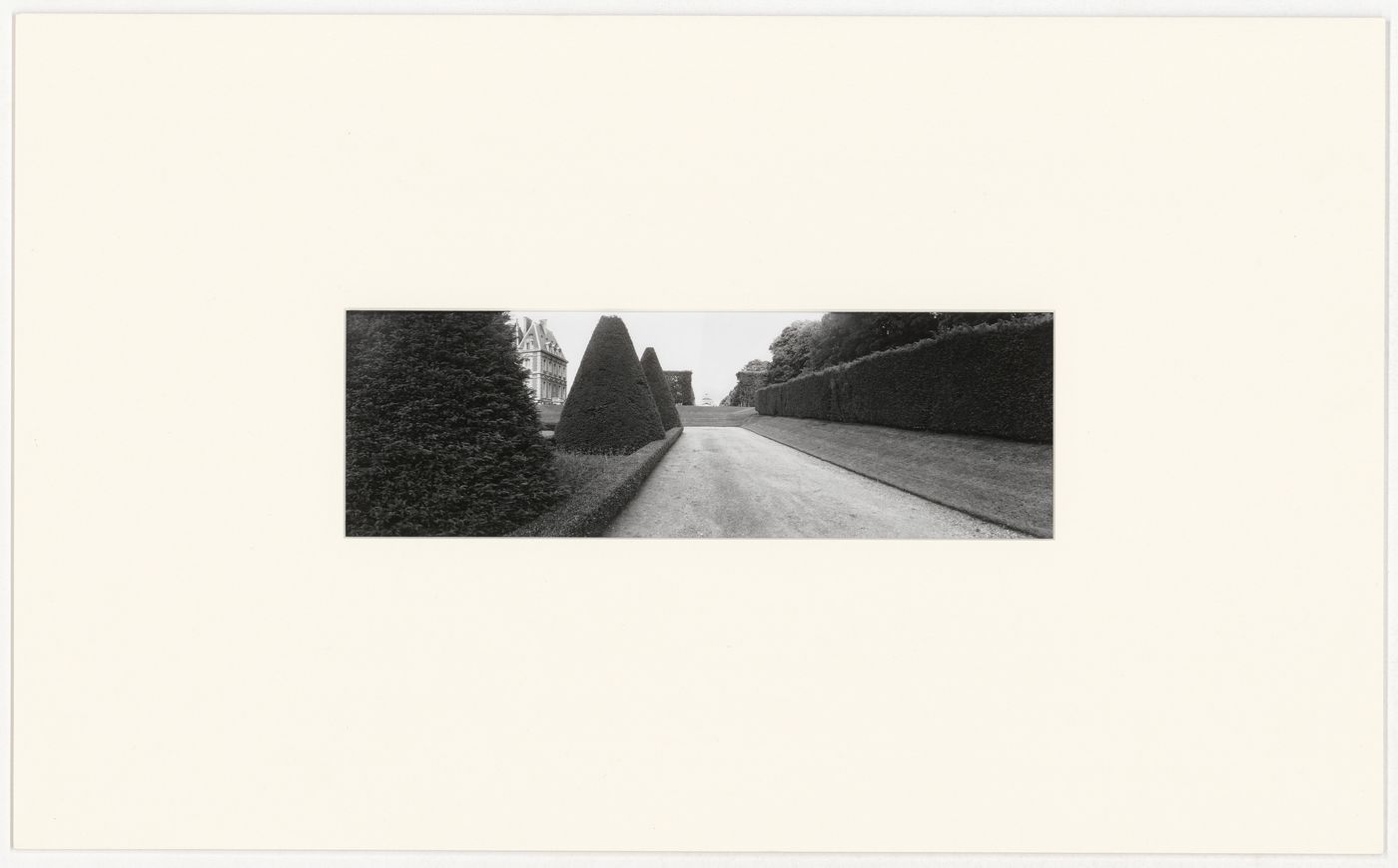 View of a walkway bordered by trees and hedges with the Orangerie on the left and the Pavillon de l'Aurore in the background, Château de Sceaux, France