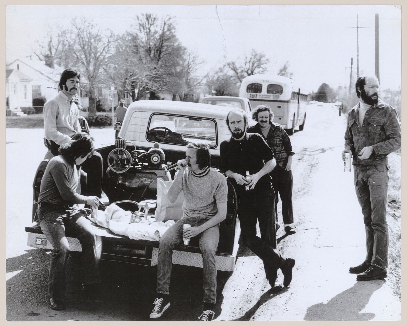 Photograph showing Pettena's team standing around a truck loaded with a paint sprayer and compressor for the Red Line project