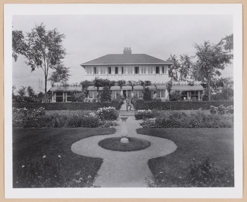 View of the rear façade of Albert Kahn's summer cottage from the garden showing a child on the stairs, Walnut Lake, Michigan