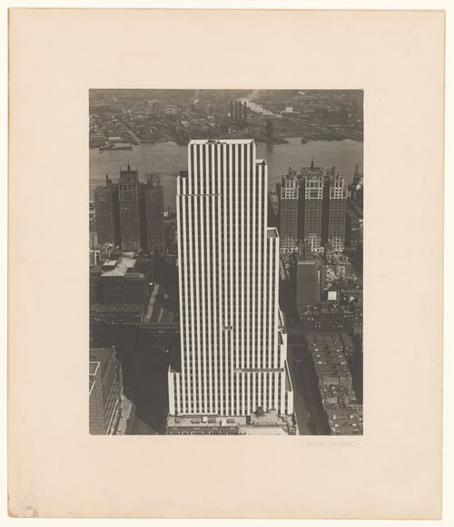 View of the Daily News Building, looking down with surrounding structures and East River, New York City, New York