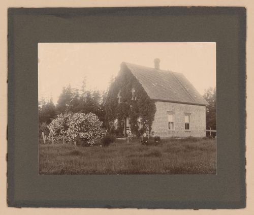 Couple sitting in front of a rural home, Prince Edward Island