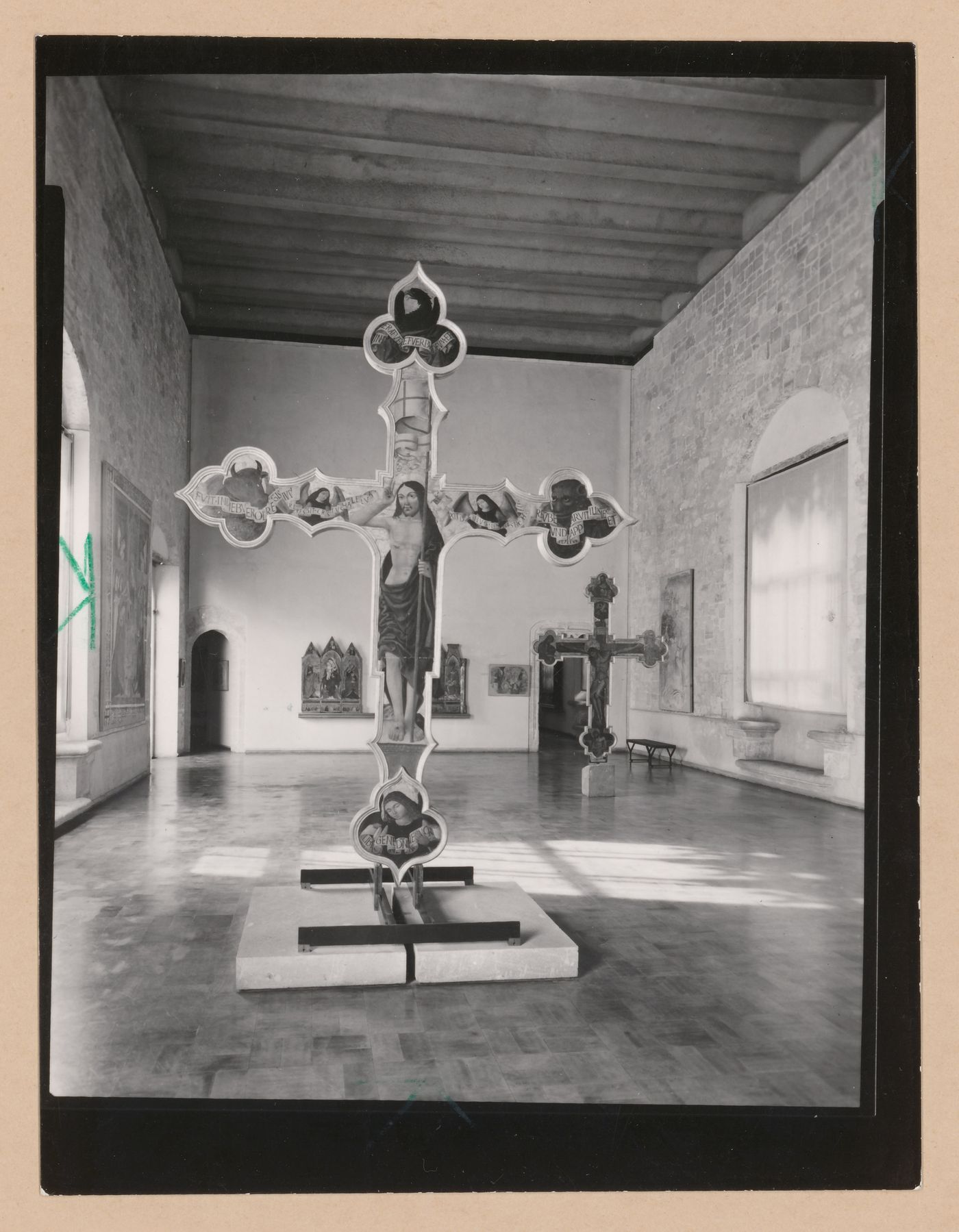 Interior view of a gallery showing two freestanding painted crucifixes and paintings, Palazzo Abatellis, Galleria regionale della Sicilia, Palermo, Italy