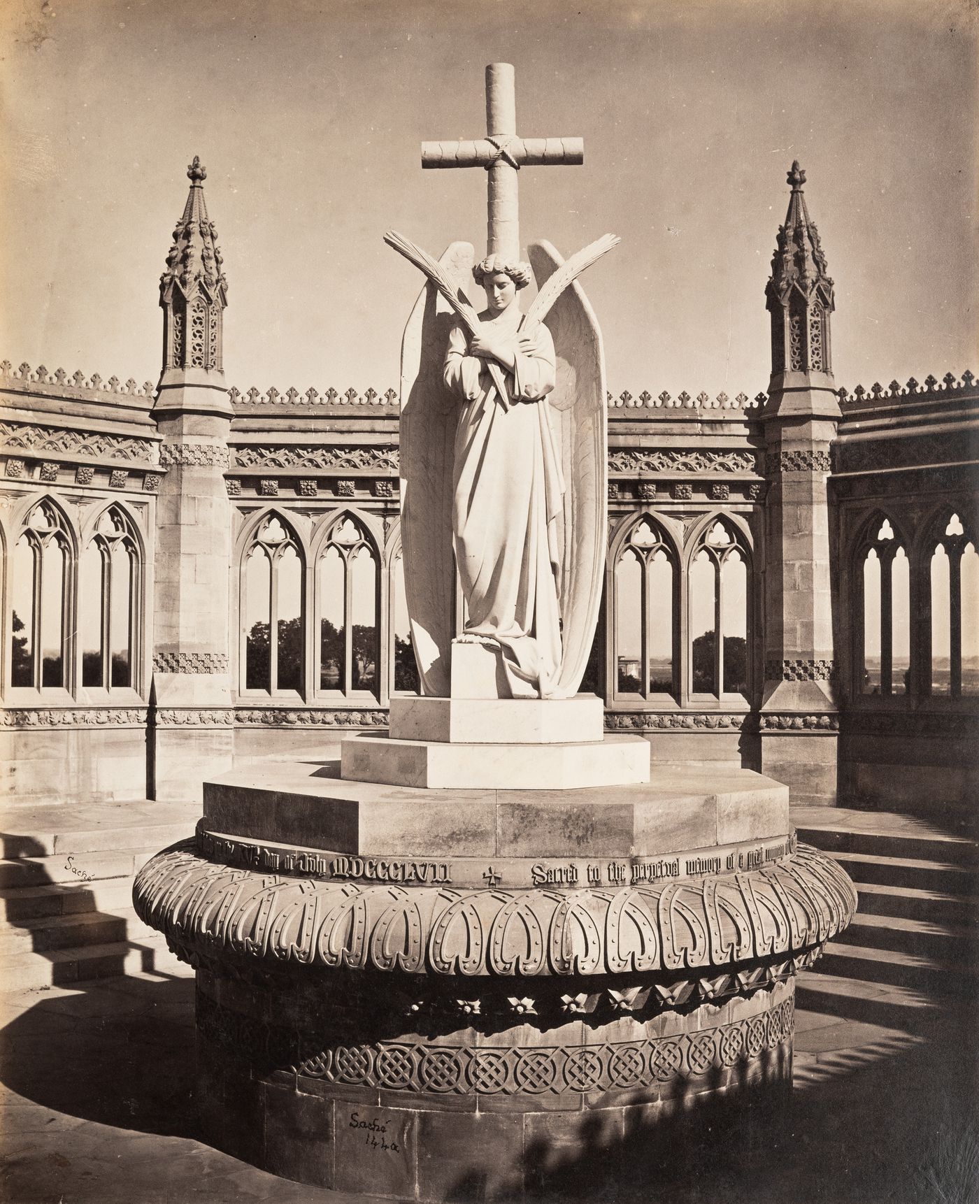 View of a statue of an angel standing on a pedestal and with an arcade in the background, Kanpur, India