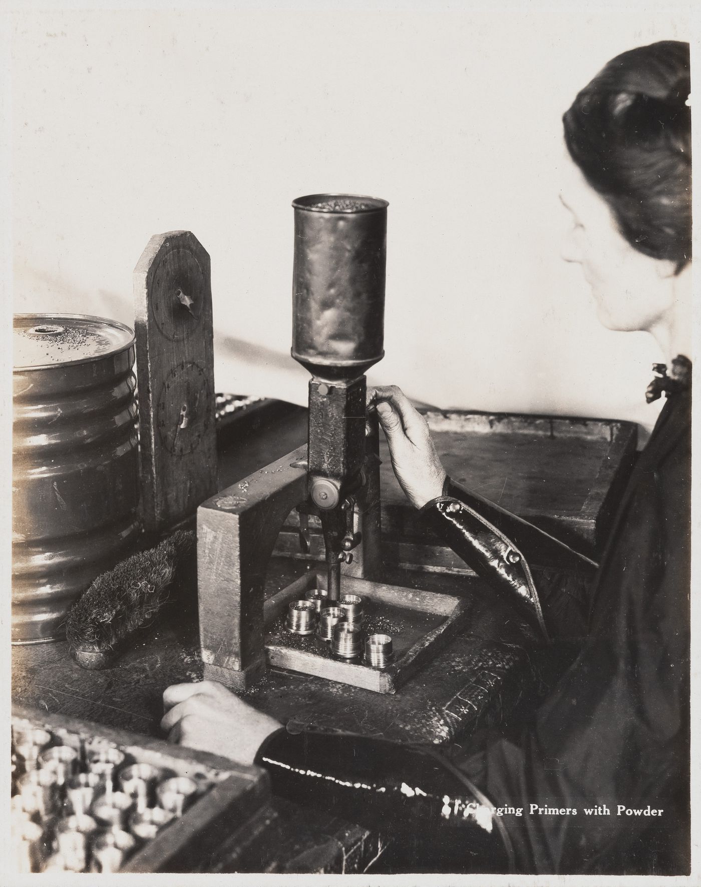 Interior view of worker charging primers with powder at the Energite Explosives Plant No. 3, the Shell Loading Plant, Renfrew, Ontario, Canada