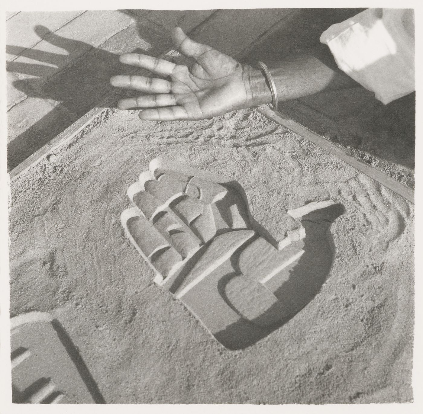 Photographs of an imprint of a hand in sand in Chandigarh, India
