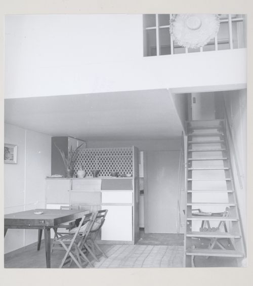 Interior view of an apartment dining alcove showing a table, chairs and stairs to the mezzanine, Unité d'habitation, Marseille, France