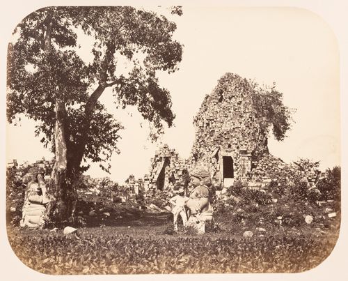 View of the ruins of stupas showing statues of Gupolo and a man, Candi Sewu, near Prambanan, Dutch East Indies (now Indonesia)
