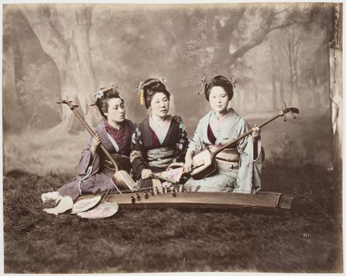 Group portrait of three women with two shamisen, a koto and fans, Japan