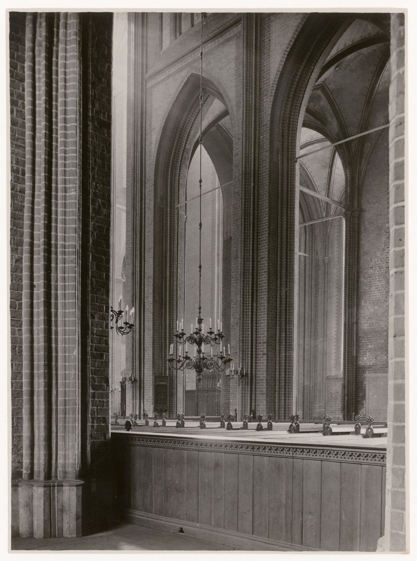 Detail, interior of unidentified church, showing brick piers of vaulted nave, and enclosed pews, Lübeck, Germany