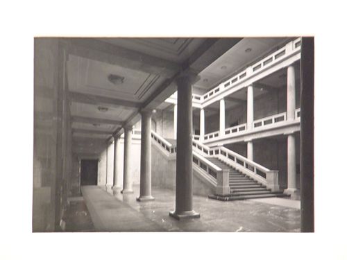 Interior, view at an angle of large staircase in two-story interior courtyard of large building, England
