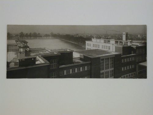 Panoramic view of building rooftops and a field with the city in the right background, Hradec Králové, Czechoslovakia (now Czech Republic)