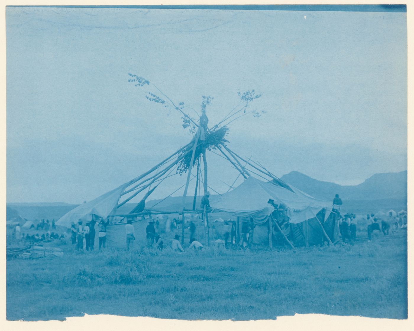 View of a round lodge under construction, probably a Cheyenne Sun Dance lodge, United States