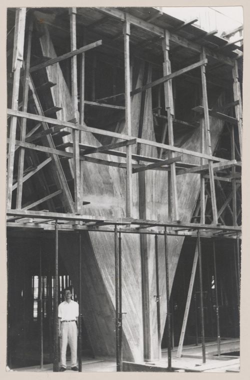 View of Governor Juscelino Kubitschek's Complex, under construction, with man standing under scaffolding, Belo Horizonte, Brazil
