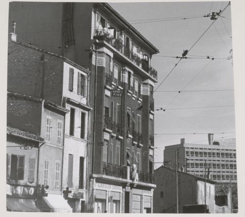 Distant view of the north and west façades of Unité d'habitation with a commercial street in the foreground, Marseille, France