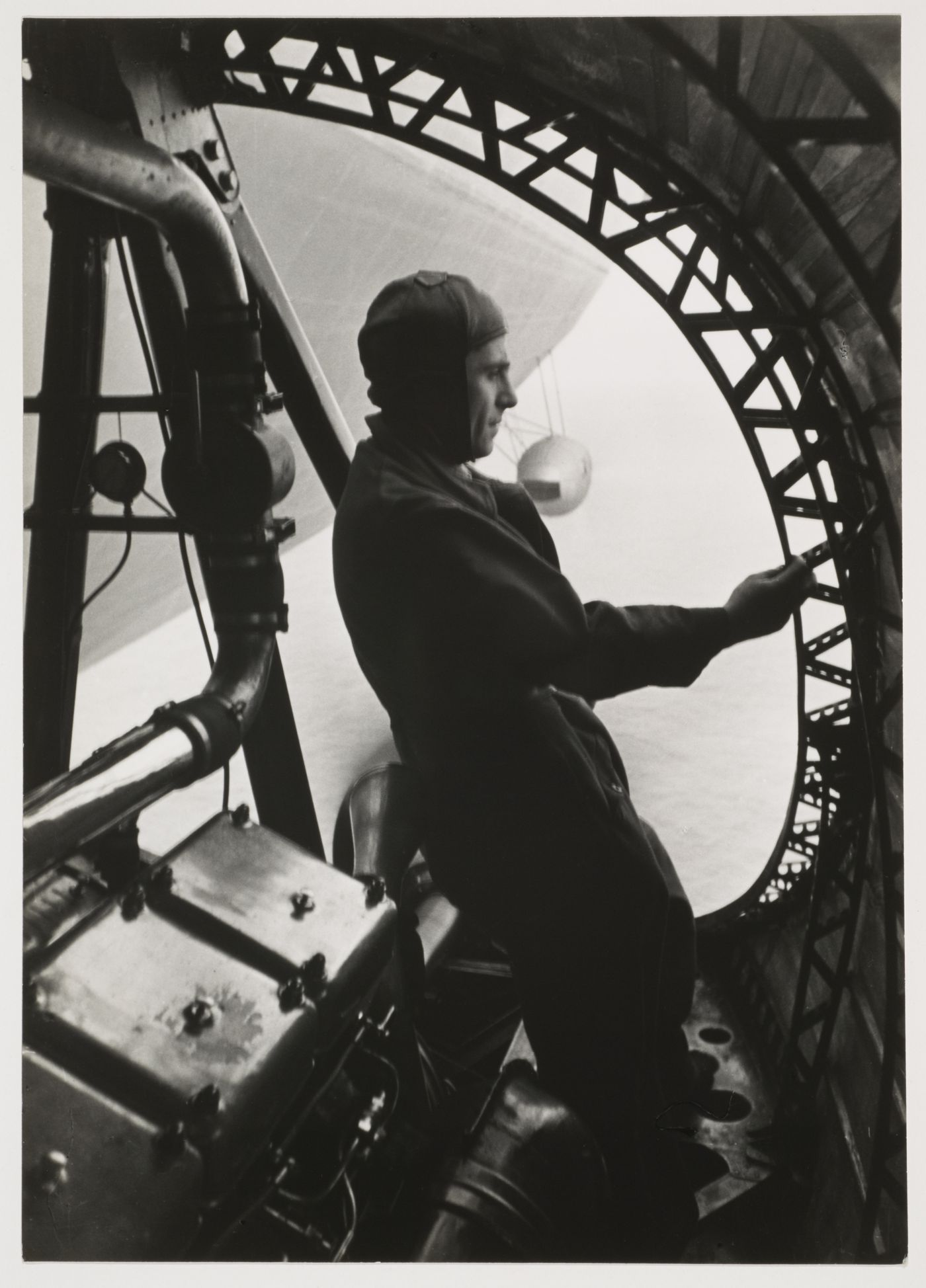 View of a zeppelin in flight from the rear propellor duct with a technician verifying [?] the metal structure