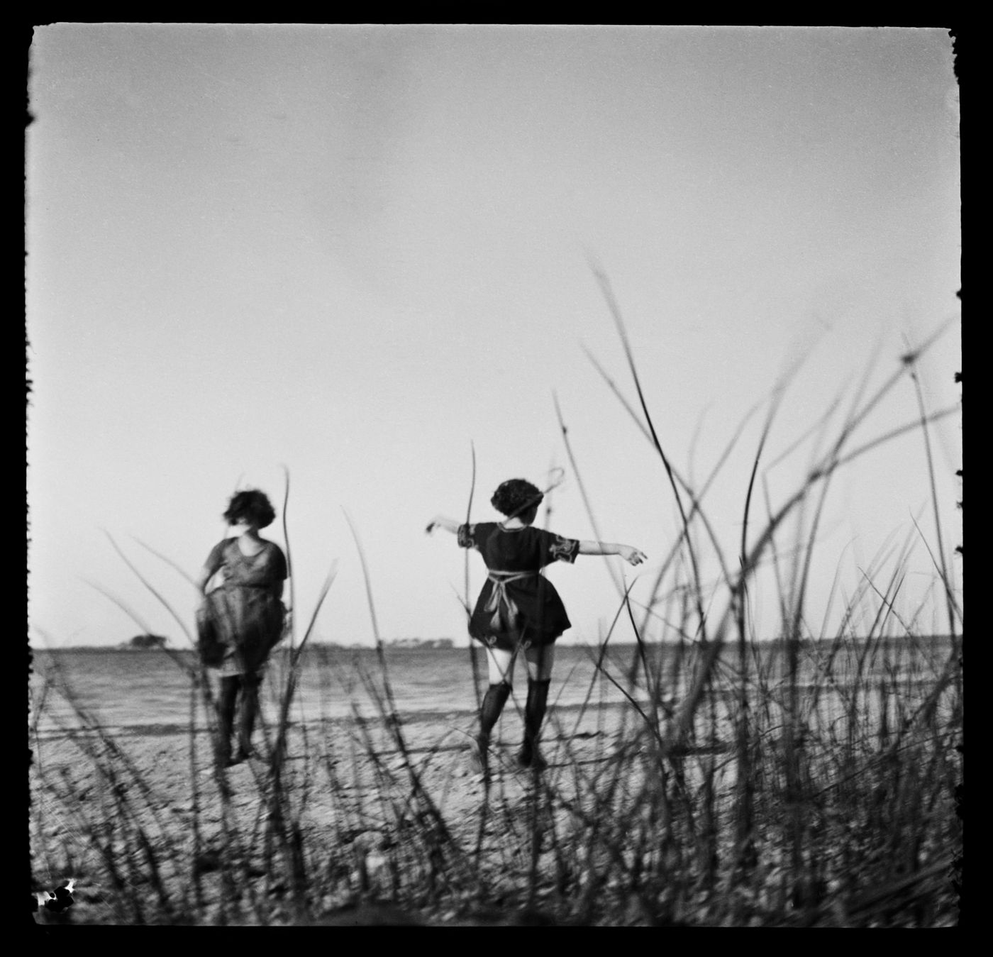 Portrait de deux femmes non identifiées, possiblement Clorinthe et Cécile Perron, près de la rive d'une étendue d'eau