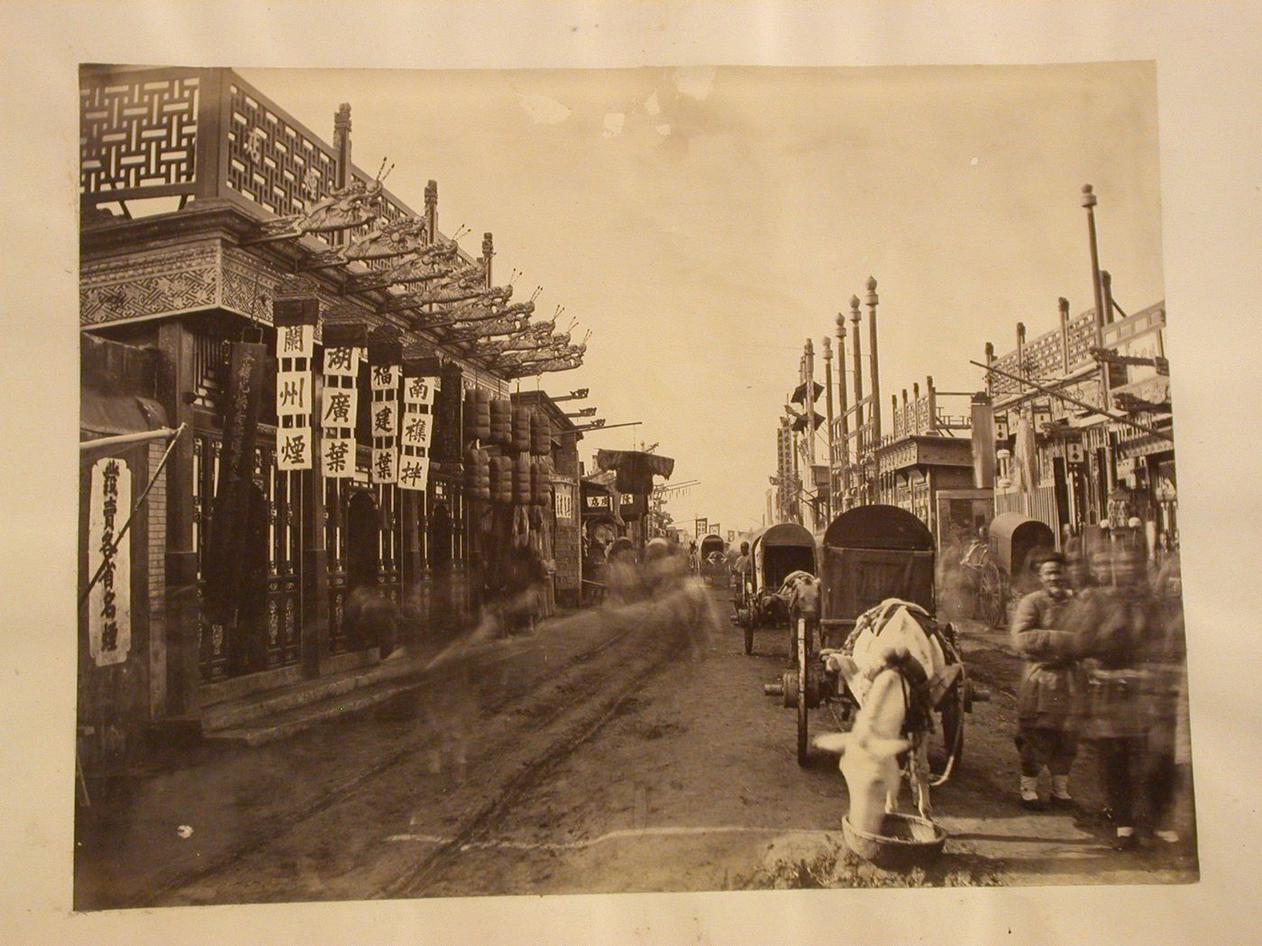View of storefronts on a Peking (now Beijing) street