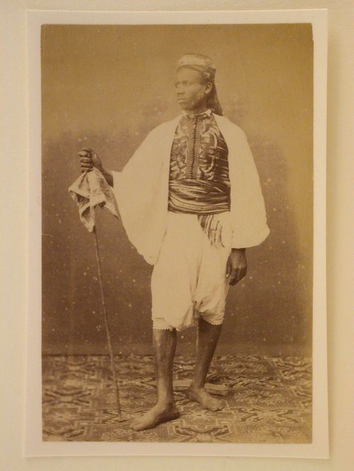 Standing man with walking stick and photographers support brace in background