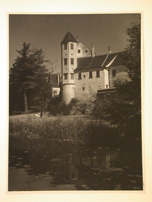 Rear view of buildings and a tower from across a pond, possibly showing a part of Telc Château, Telc, Czechoslovakia (now Czech Republic)