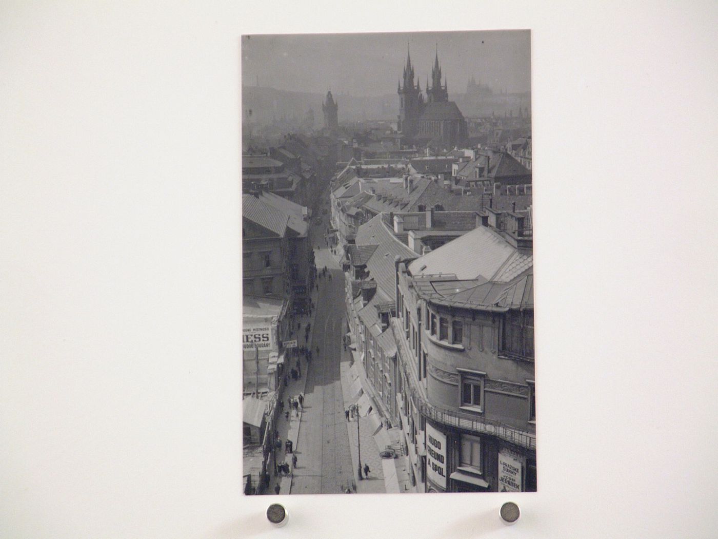 View from above down a narrow street, with large church or cathedral in distance, Prague, Czech Republic