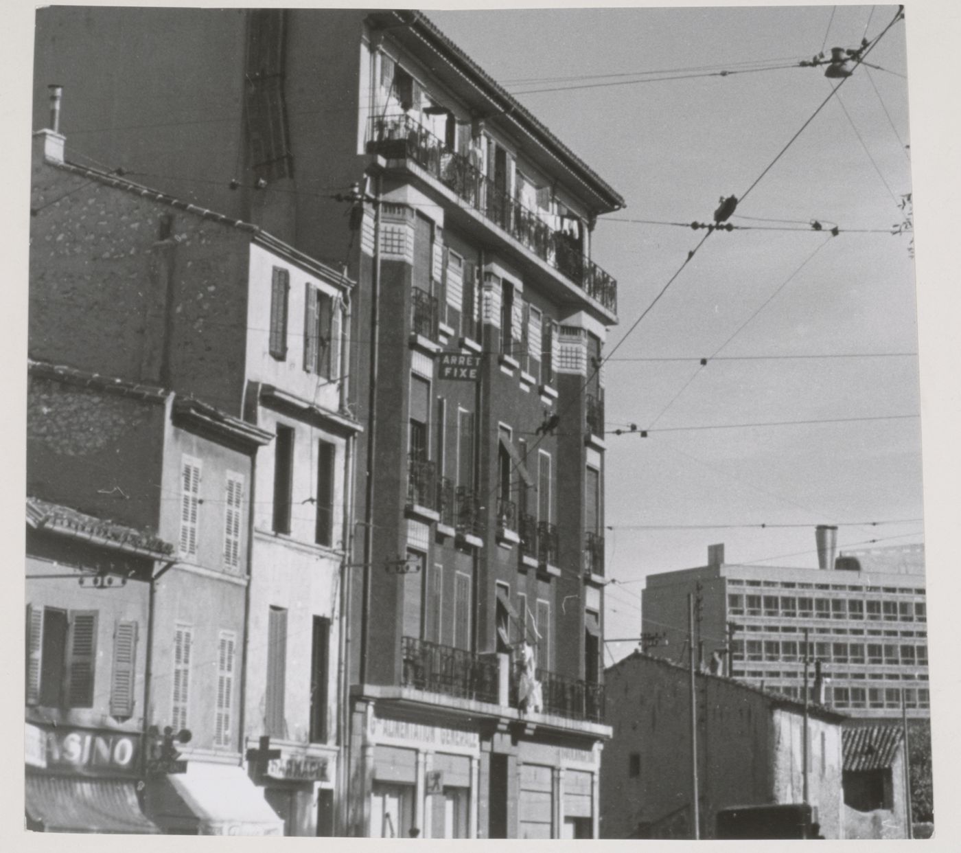 Distant view of the north and west façades of Unité d'habitation with a commercial street in the foreground, Marseille, France