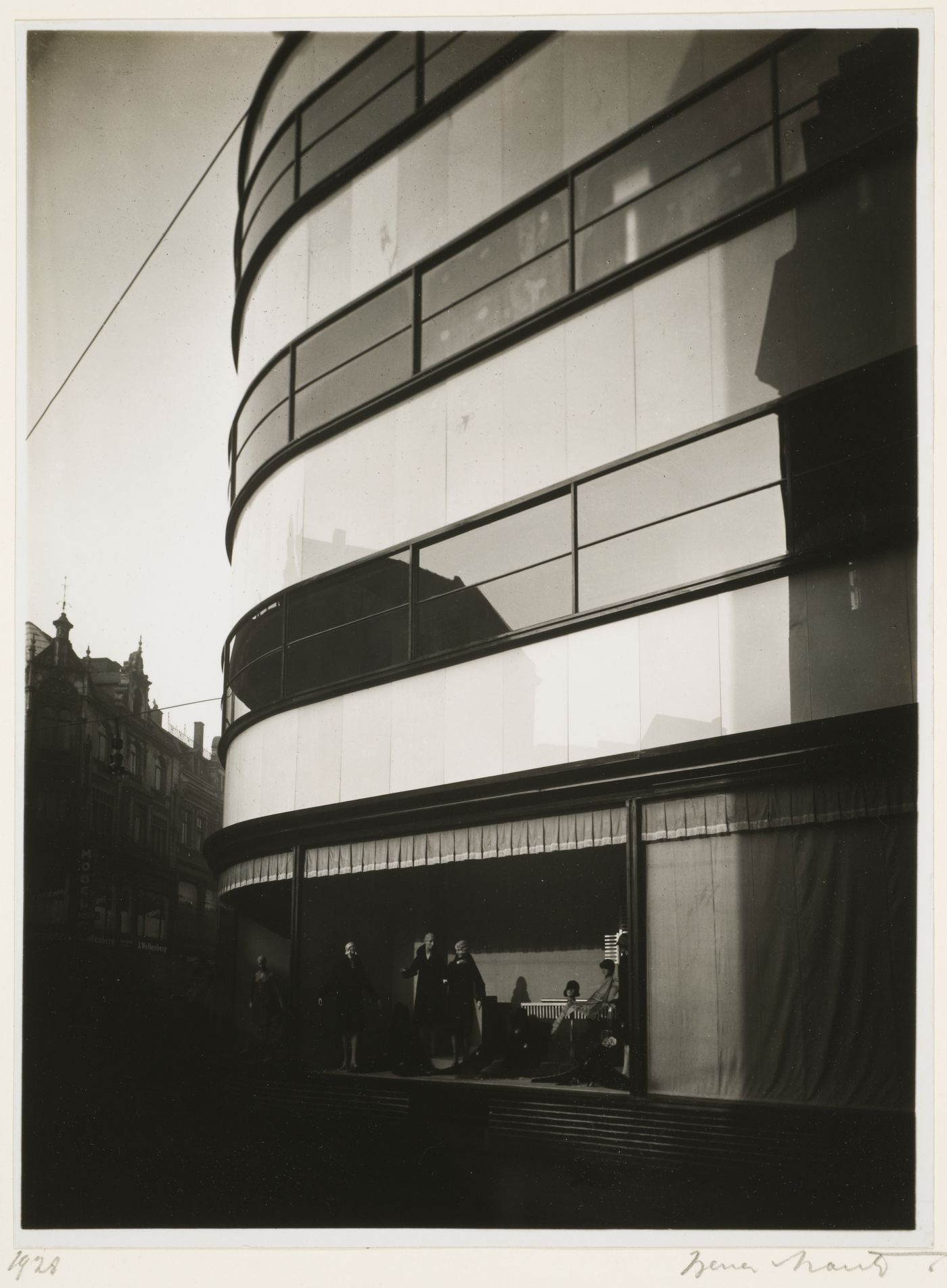 Exterior view of façade of department store showing four stories, with man niking in window, Gelsenkirchen, Germany