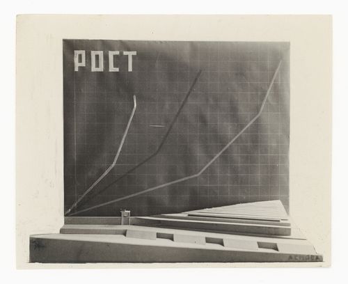 Photograph of a side elevation of a model for a Palace of Soviets showing a chart titled "ROST" [GROWTH], Moscow