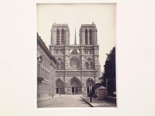 Exterior view, façade of Notre Dame, with houses at left, Paris, France