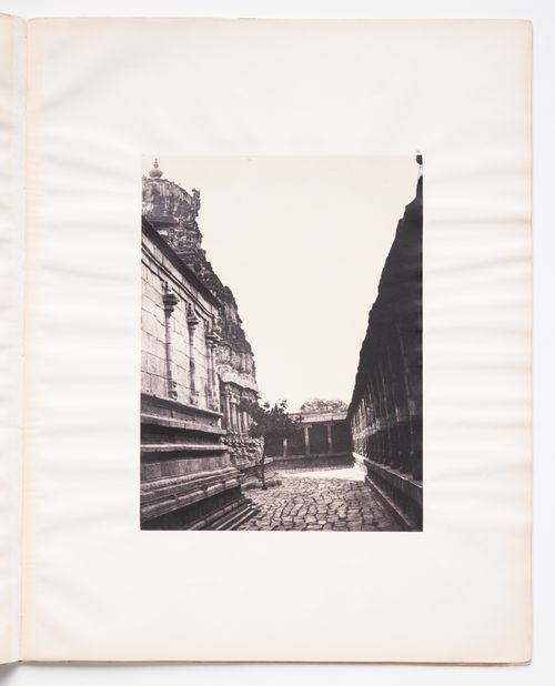 View of a paved path showing part of the Sundareswara temple on the left and part of a gopura [?] on the right, Madura (now Madurai), India