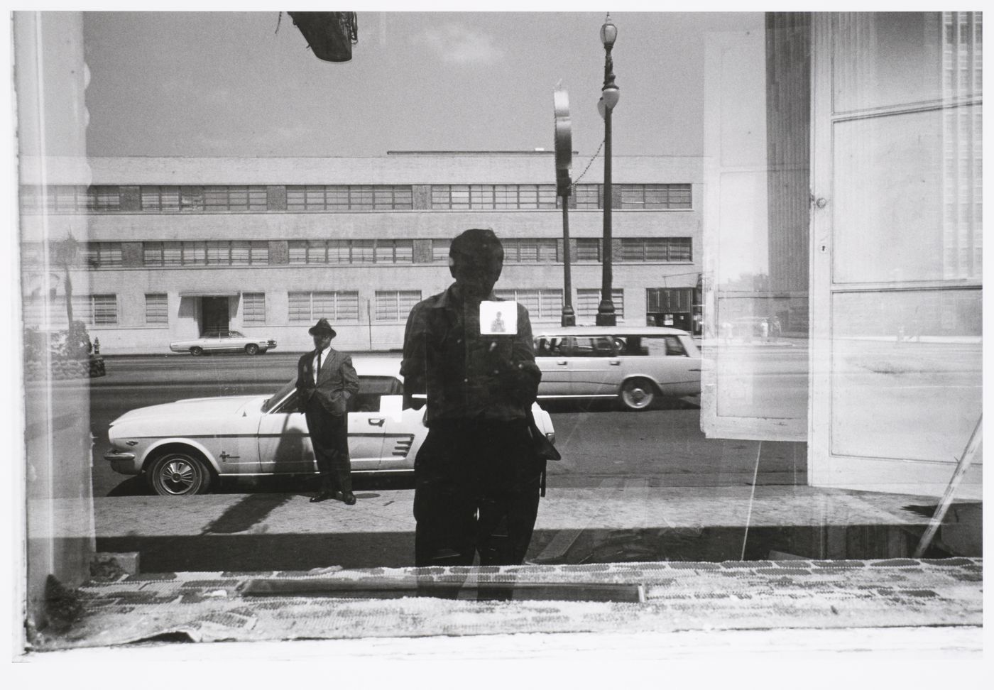 Double self-portrait with Polaroid picture taped to window reflecting artist and street scene, New Orleans, Louisiana