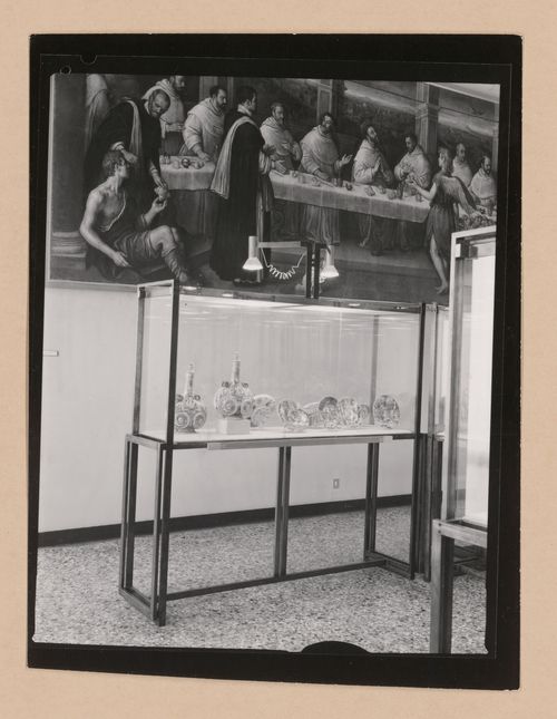 Interior view of a gallery showing a partial view of a painting of the Last Supper with a display case containing painted dishes in the foreground, Museo Correr, Venice, Italy
