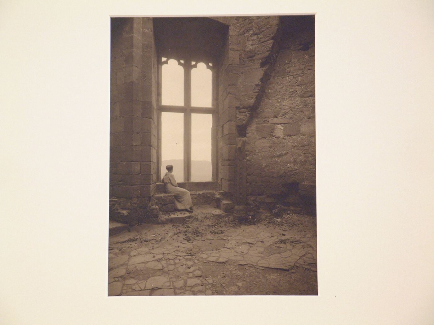 Unidentified ruins, presumably medieval, with woman sitting, in window